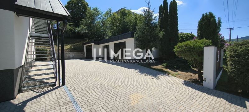 A courtyard with a staircase, garages, and trees near a 4-room apartment in Jasenov.