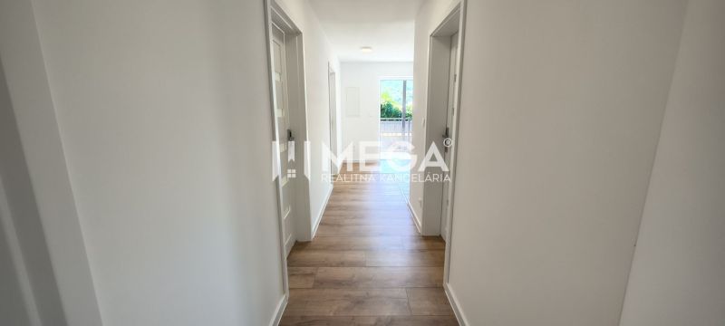 Hallway in a 4-room apartment, wooden decor flooring, light walls, entrance to the balcony.