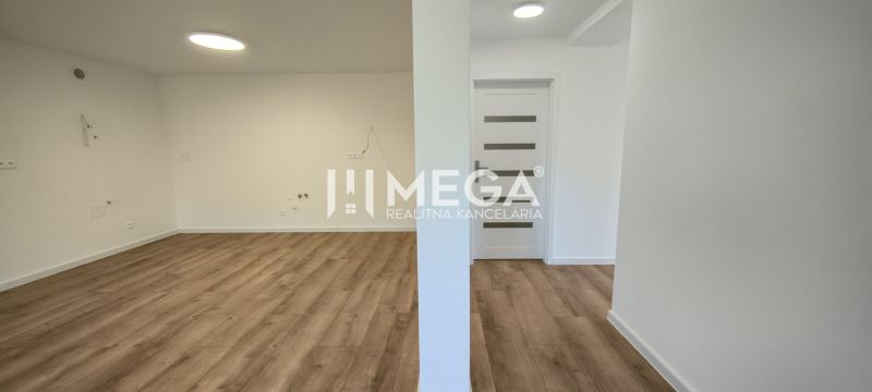 A spacious area with light walls and a wooden decor floor in a 4-room apartment.