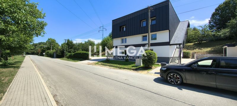 A path with a sidewalk leading to a 4-room apartment in Jasenov lined with greenery.