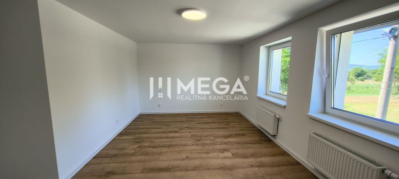 A room in a 4-room apartment with white walls and a floor with a wood decor.