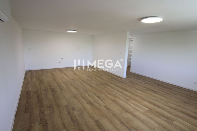 A spacious room with light-colored walls and a wooden decor floor in a 4-room apartment.