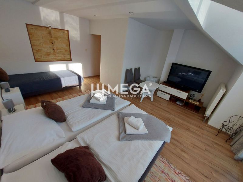 Room in hotels and guesthouses with beds, wooden decor flooring, and a television.