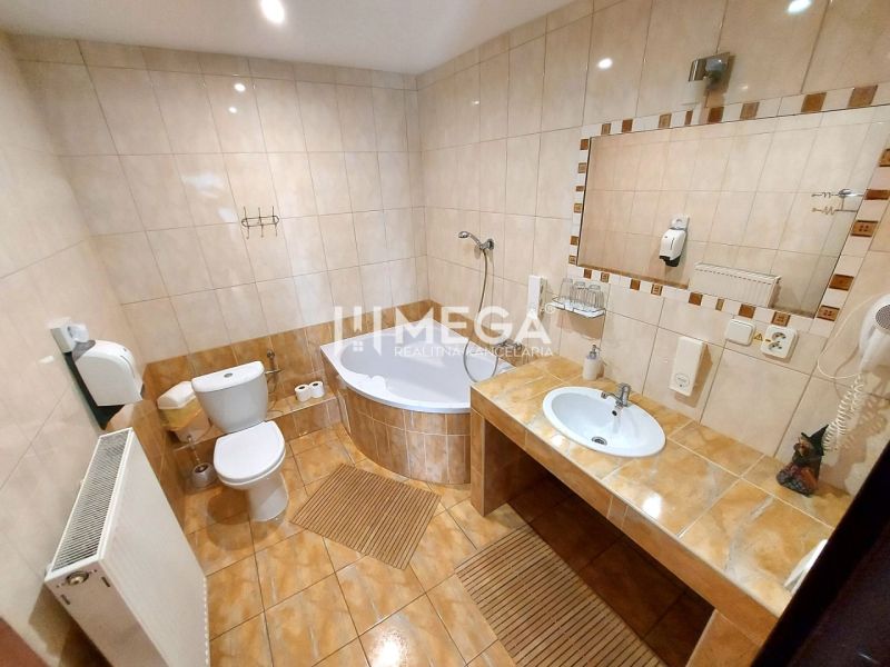 Bathroom in hotels and guesthouses with a bathtub, toilet, and large mirror.