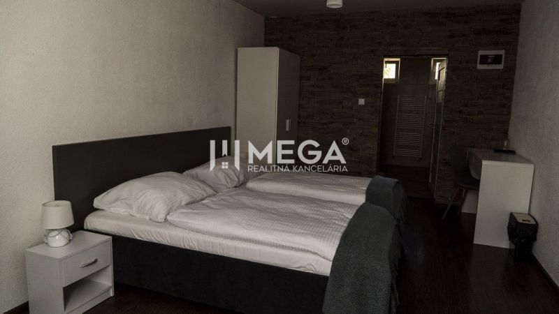 A room with two beds, a table, and a floor with a wooden decor. Hotels and guesthouses.