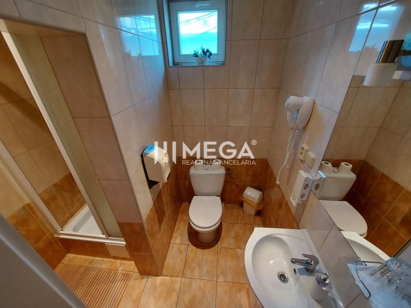 Bathroom with toilet, shower, sink, and hairdryer in hotels and guesthouses.
