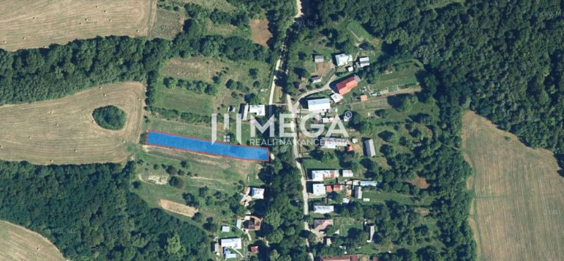 Aerial view of residential plots in Vyšné Ladičkovce surrounded by fields and forest.