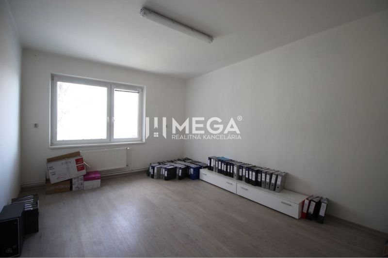 An empty office with a window and a wooden floor, full of binders.