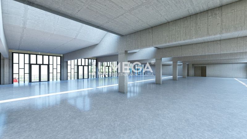 A large glass hall in commercial premises with concrete columns and a smooth floor.