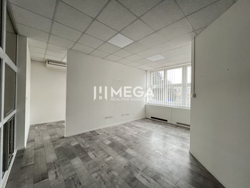 Offices with wood-patterned flooring, light-colored walls, and large windows.