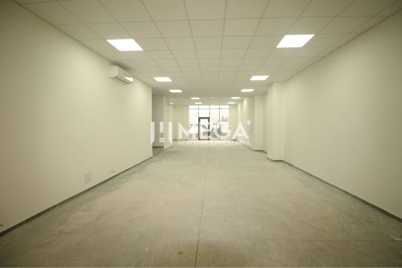 Interior of a commercial space with white walls and textured flooring without decor.