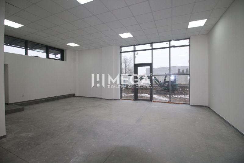 Interior of commercial spaces with large windows and frosted ceiling lights.