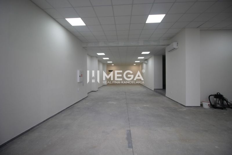 A large empty commercial space with white walls and tiled flooring.