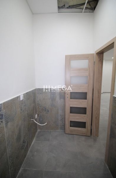 Commercial premises with a tiled wall and wooden doors.