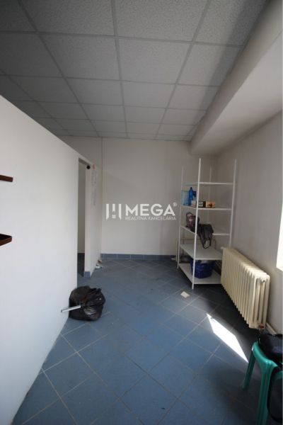 Interior of commercial premises with a blue floor, shelf, and radiator.