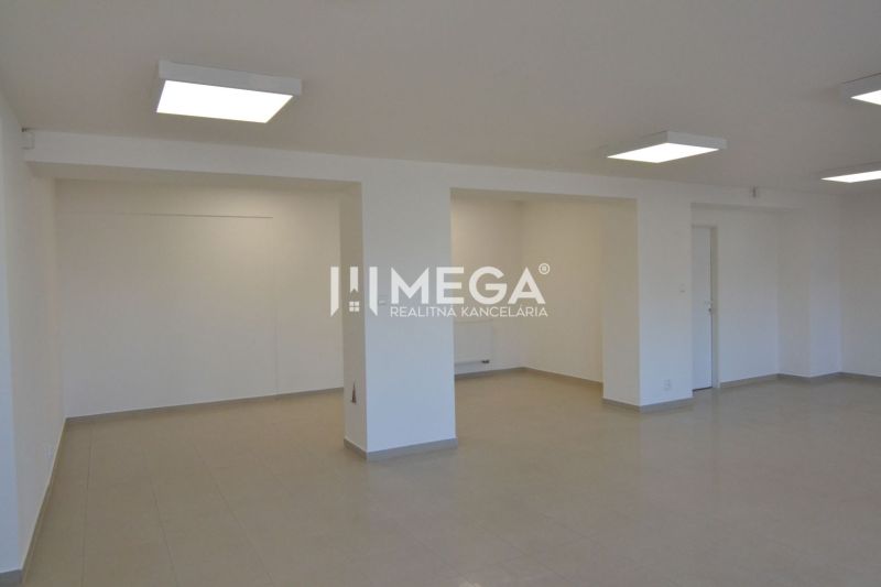 Commercial spaces with white walls and tiles, sets of lights on the ceiling.