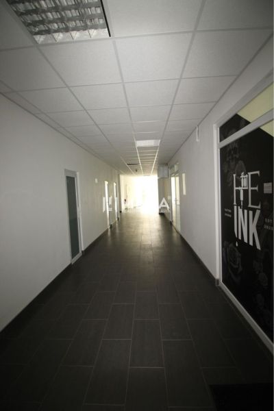 A long corridor in an office with a dark floor and a white ceiling.