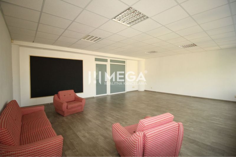 An office with four chairs, a wooden floor, and a large board.
