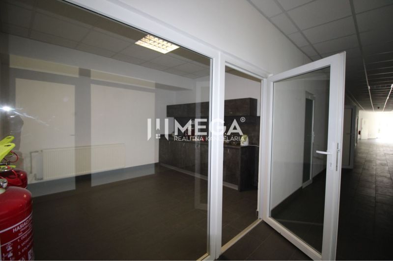 Glazed entrance doors in an office with tiles and fire extinguishers.