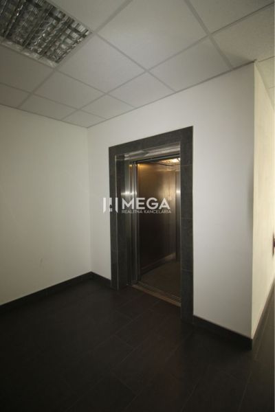 Offices with dark flooring and an elevator.