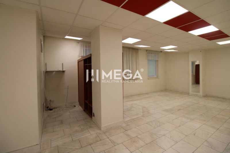 Spacious commercial spaces with tiles and wall shelves, neutral colored walls.