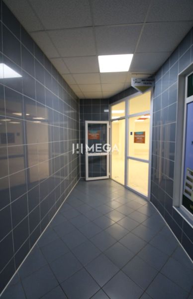 A corridor with a tiled floor and glass doors in commercial premises.