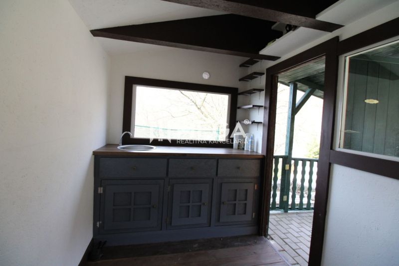 Interior with a kitchen unit, window, and floor with wood decor in Gardens.