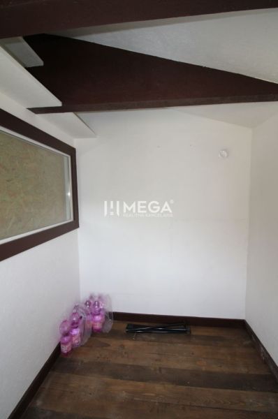 A room with ceiling beams, a floor with a wooden decor, and packaged drinks in the Gardens.