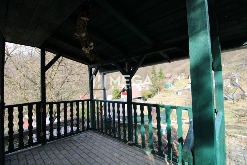 Covered terrace with green railing in the Gardens at ZO Poniklec, Humenné.