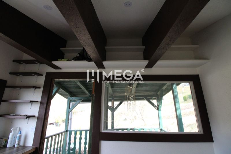 Interior with built-in shelves and glass doors overlooking the porch in the Gardens.