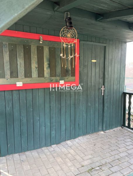 Garden at ZO Poniklec in Humenné with wooden decoration on the wall.