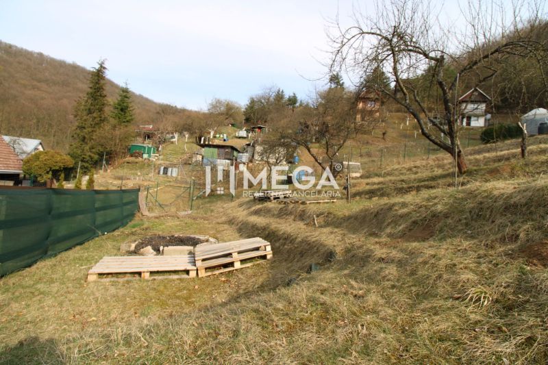 Gardens on ZO Poniklec Street in Humenné with several trees and wooden pallets.