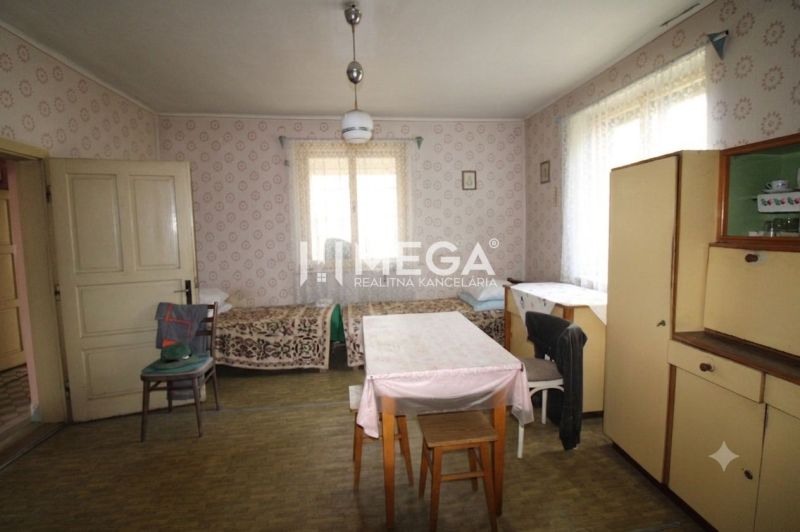 Interior of a family house with retro furniture, two beds, and a wooden decor floor.