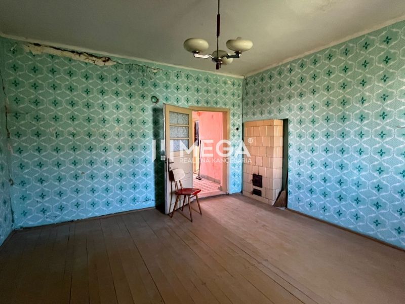 A room with wallpaper in a family house with a wooden decor floor and tiles.