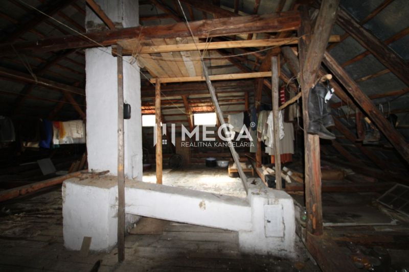The attic of a family house with wooden beams and storage items.