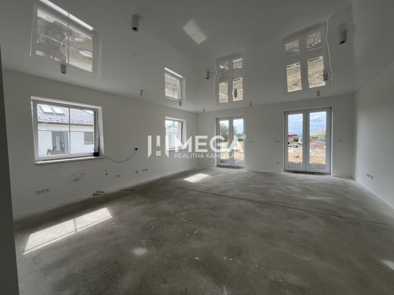 A spacious, bright room with large windows in a family house.
