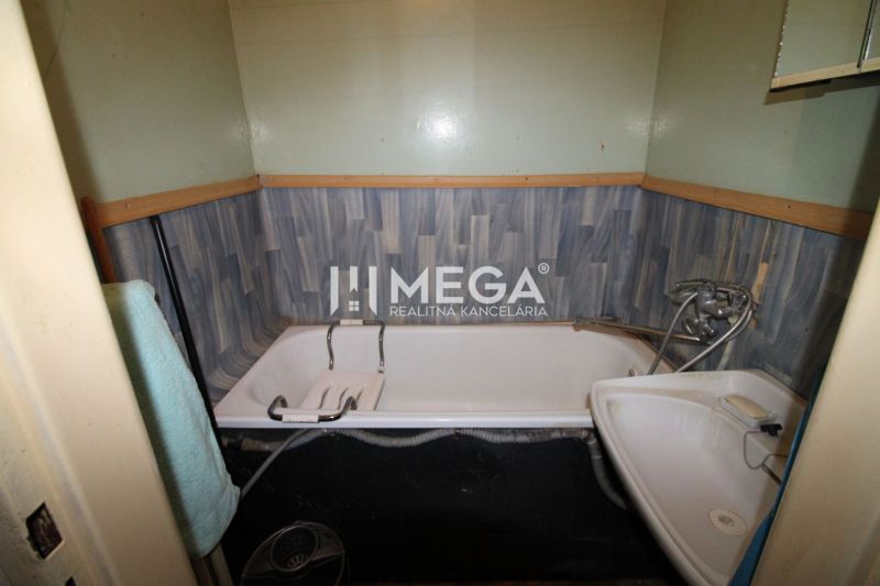 A bathroom with a bathtub and a sink in a 2-room apartment.