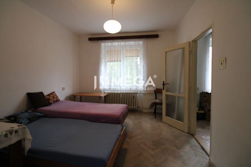 Bedroom with two beds and a wooden decor floor in a two-room apartment.