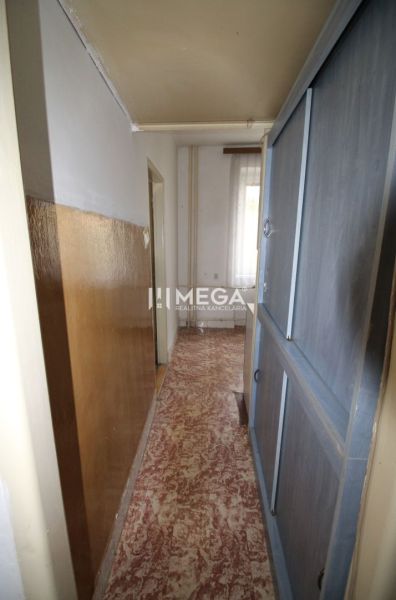 A narrow hallway in a 2-room apartment with linoleum and built-in wardrobes.