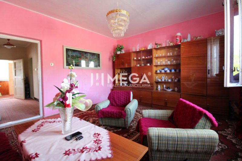 Living room in a family house with pink walls, furniture, and decorations.