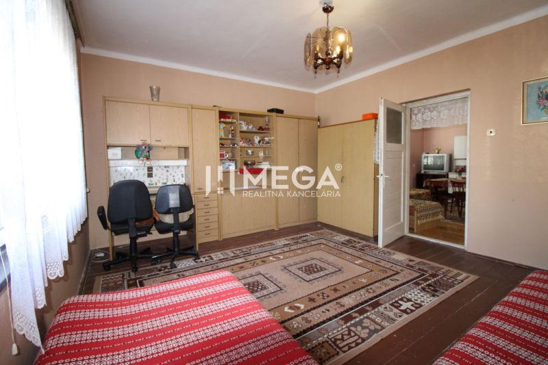 Interior of a family house with a carpet, a desk and chairs, and a door to another room.