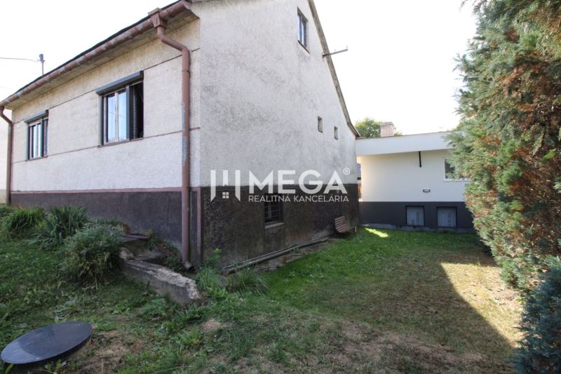 A family house on Volica Street in the town of Volica with a grassy yard and shrubs.