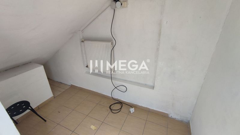 A small room with white walls, a chair, and a radiator, commercial premises.