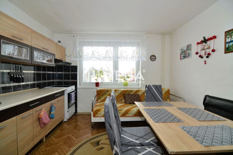 A kitchen in a family house with a kitchen unit and a dining table, a floor with a wooden decor.