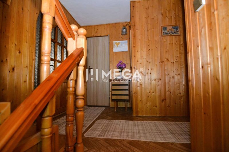 Interior of a family house with a staircase, wooden paneling, and a floor with a wooden decor.