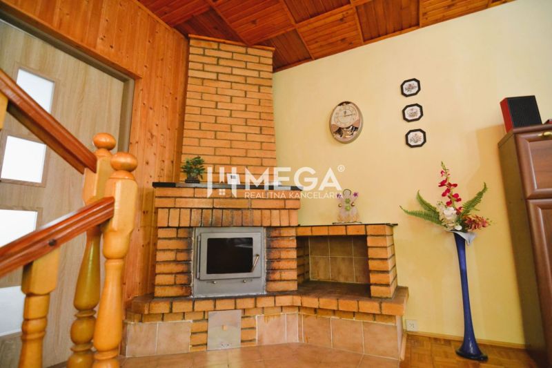 A brick fireplace in the corner of the room with decorations and a wooden decor floor.