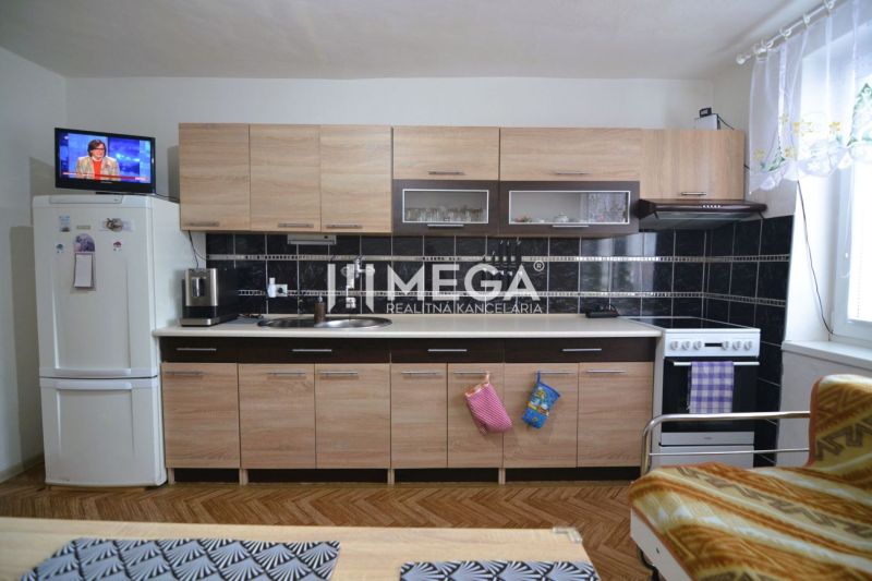 A kitchen in a family house with wooden decor flooring and light furniture.