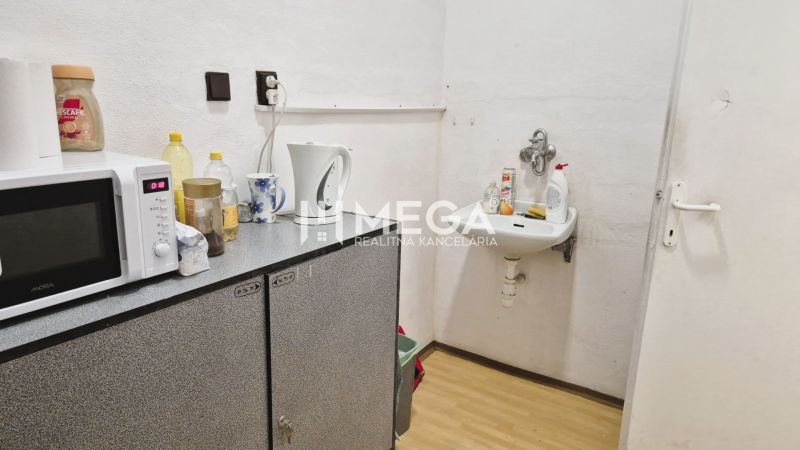 Office space with a sink, microwave, and wood-patterned flooring.