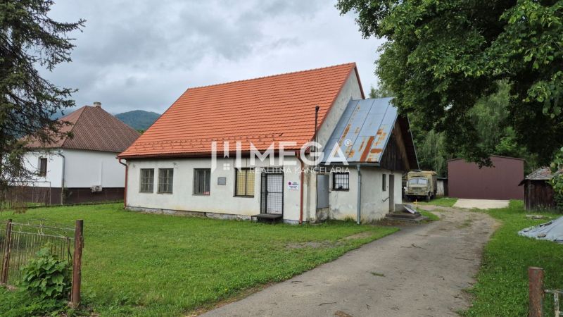 Commercial premises in Zboj with a grassy yard and an older single-story house.