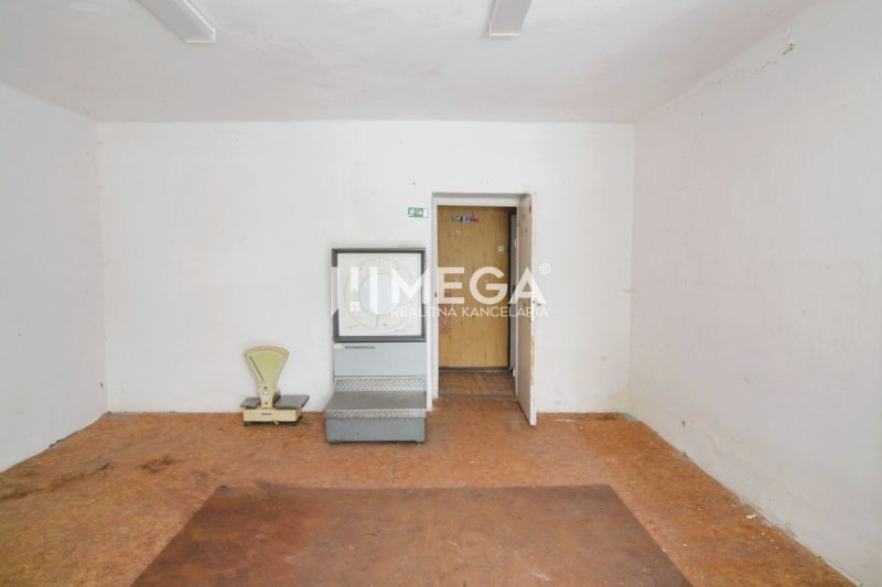 Empty commercial spaces with wood-patterned flooring and a scale for measuring.